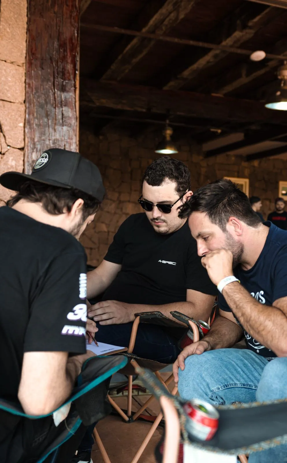 Instrutor da R37 Driver Academy fazendo anotações numa prancheta enquanto dois alunos acompanham a análise