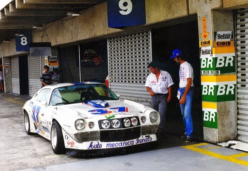 Camaro 37 branco nos boxes de Interlagos, com quatro faróis de milha na grade e o nome Auto Mecânica Renato no para-choque