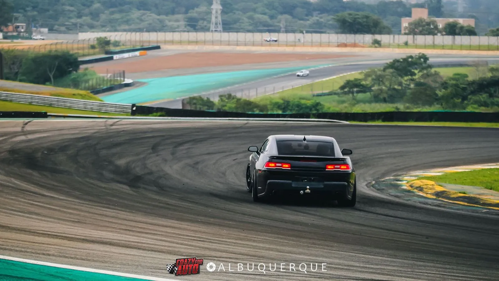 Camaro preto visto de trás contornando curva em Interlagos