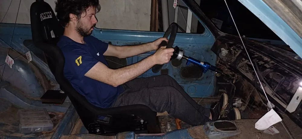 Ricardo sentado no banco Sparco dentro do carro, testando a posição de pilotagem