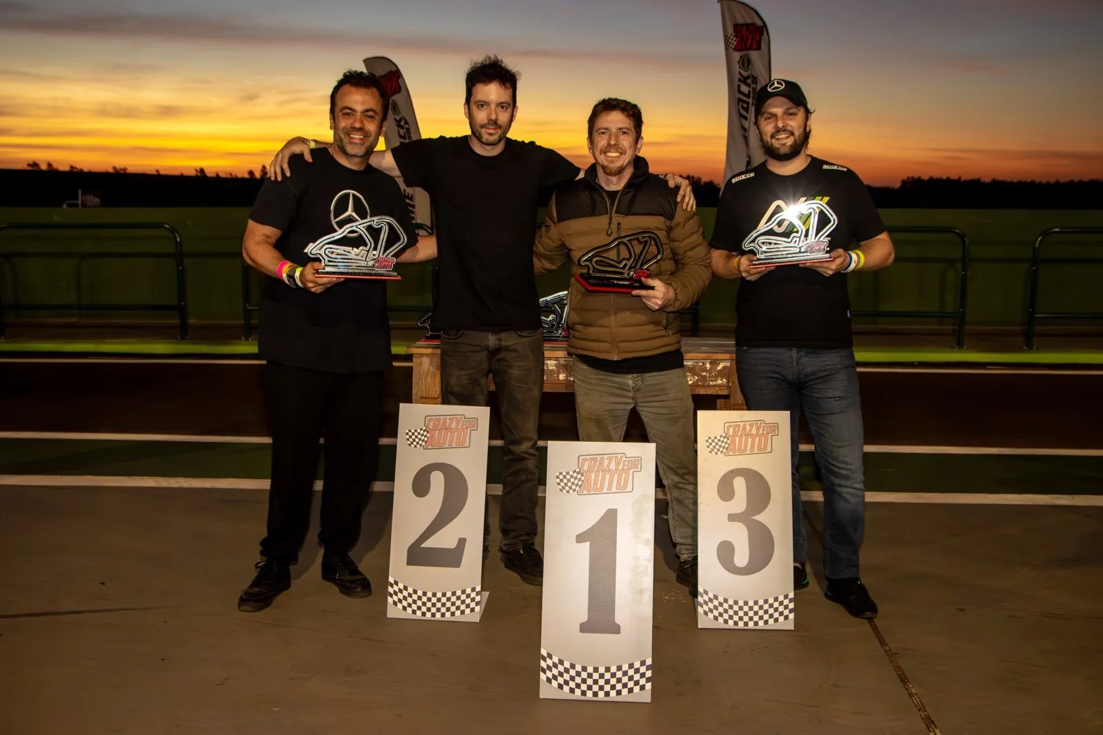 Pódio de evento Crazy for Auto ao pôr do sol, com Ricardo e Rodrigo entre os pilotos premiados
