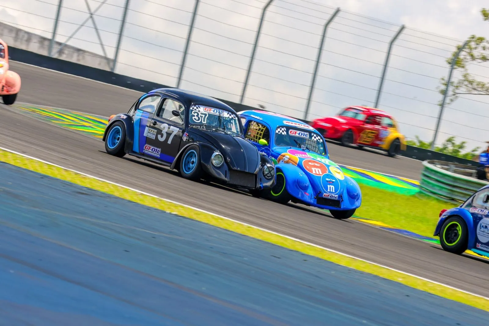 Ricardo ao volante do Fusca 37, disputando posição com um Fusca azul no S do Senna, em Interlagos
