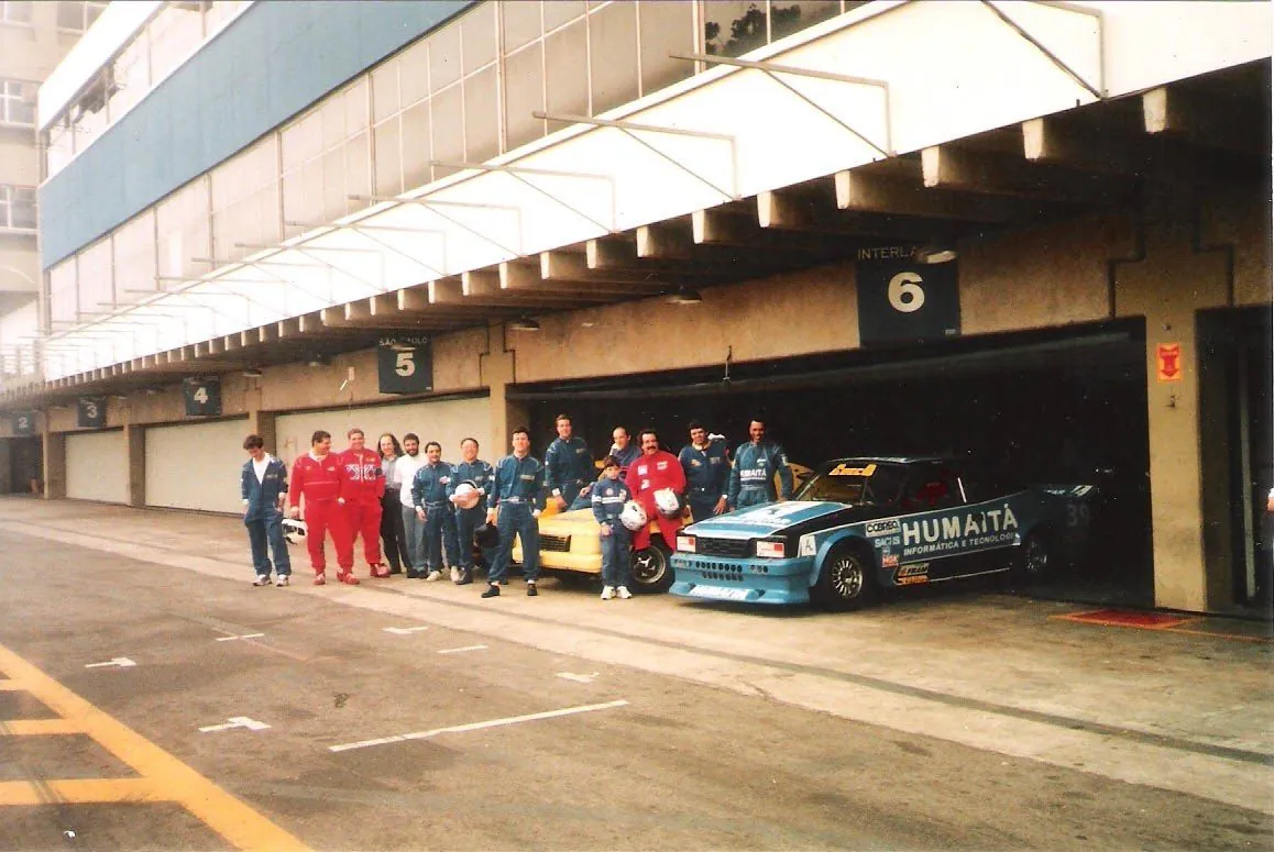 Equipe da escola de pilotagem Marazzi reunida nos boxes de Interlagos, com Ricardo criança, o pai e o Opala amarelo