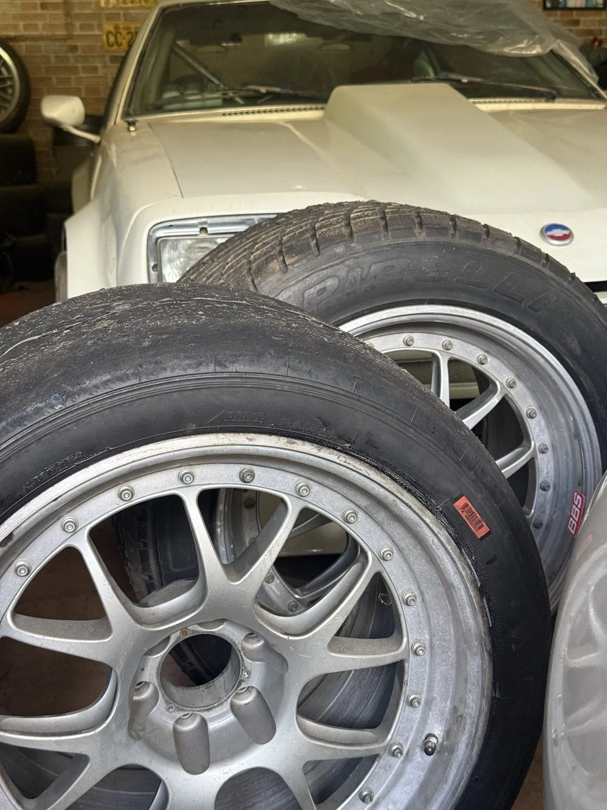 Duas rodas BBS com pneus de perfis diferentes em frente ao Monza 1975; em primeiro plano, o pneu mais baixo que será usado