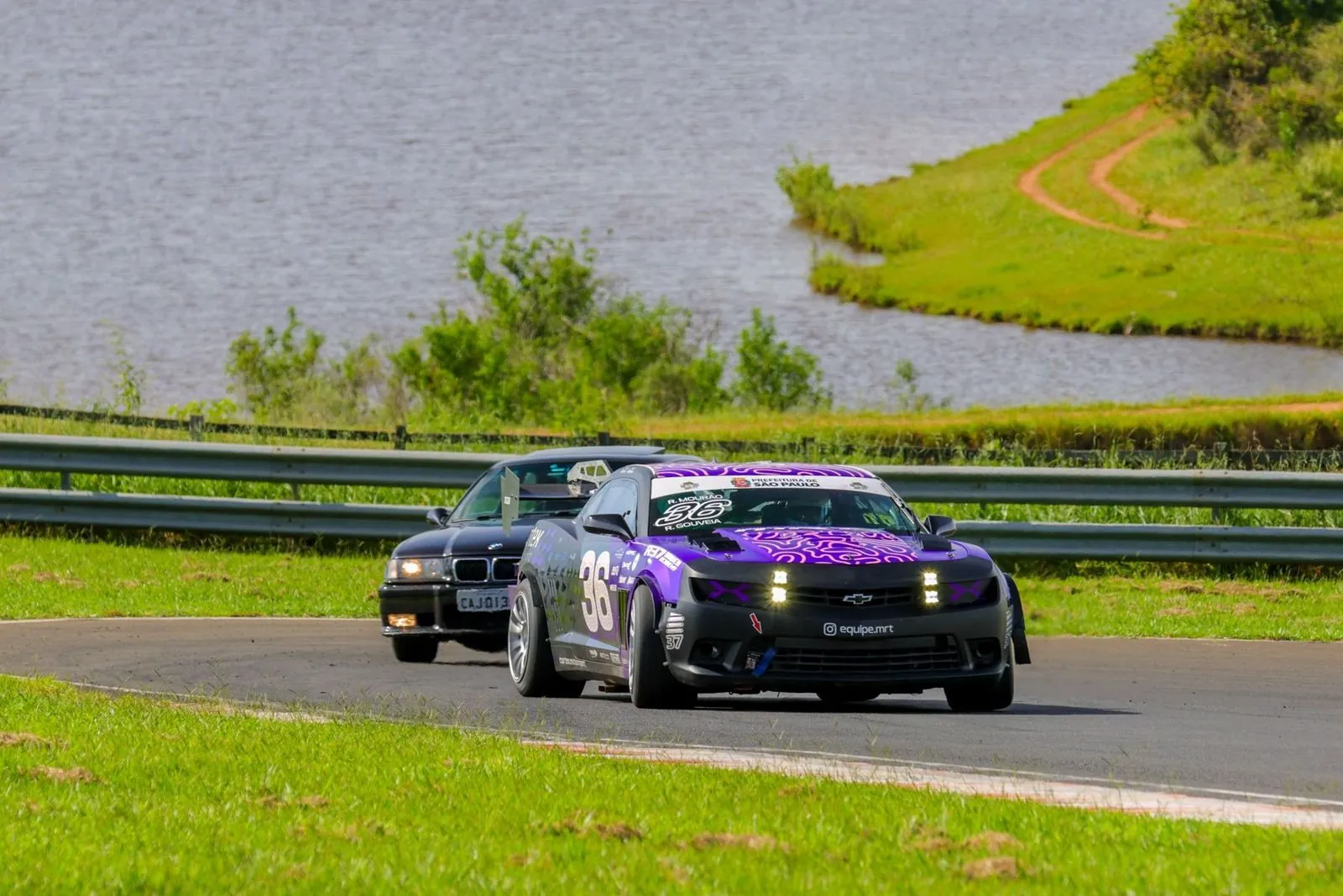 Camaro 36 contornando curva com um lago ao fundo
