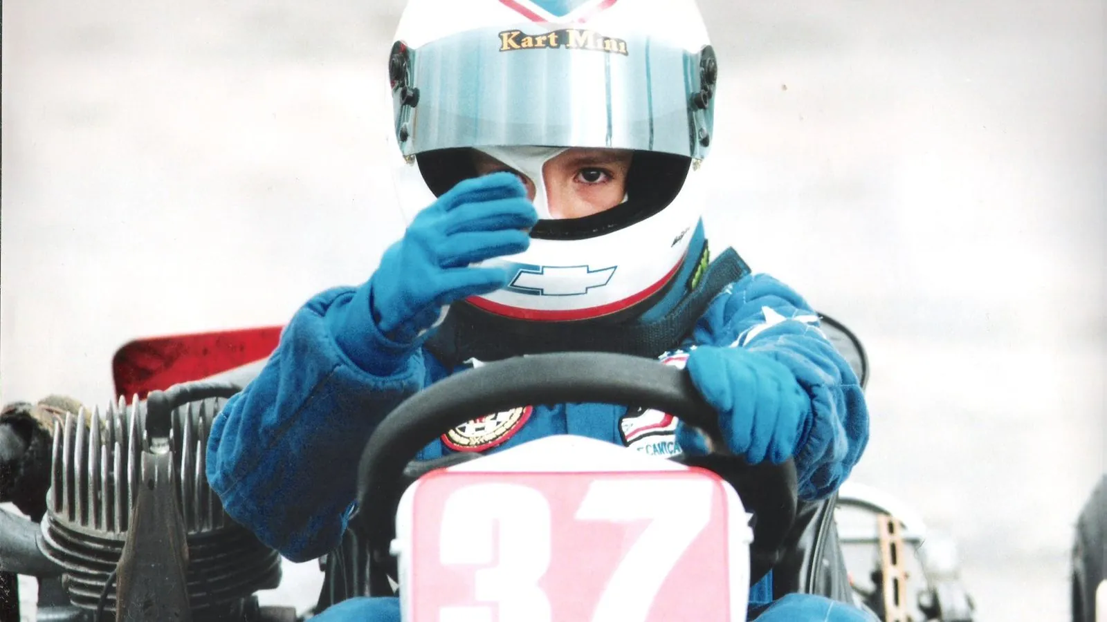 Ricardo criança no kart número 37, ajustando o capacete