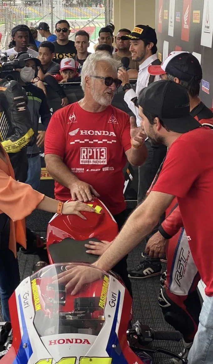 Ricardo, de boné, com a equipe RP113 ao redor da moto Honda depois da corrida